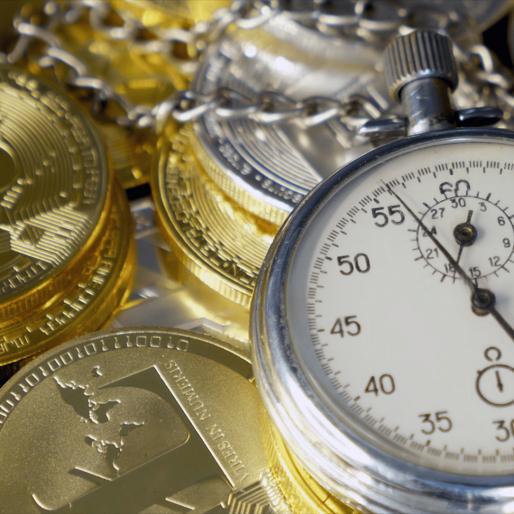 crypto coins sitting beside a pocket watch