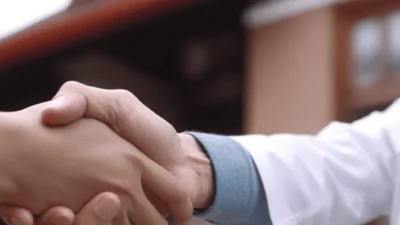 a middle aged asian man shaking hands with a doctor